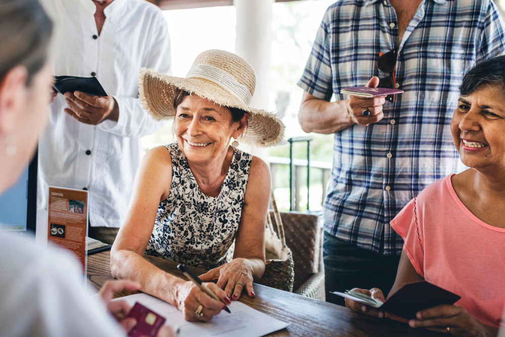 Guests checking in to a hotel, smiling and holding passports."