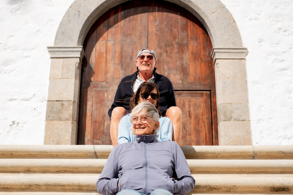 Group of senior friends sitting on steps, smiling and enjoying the day.