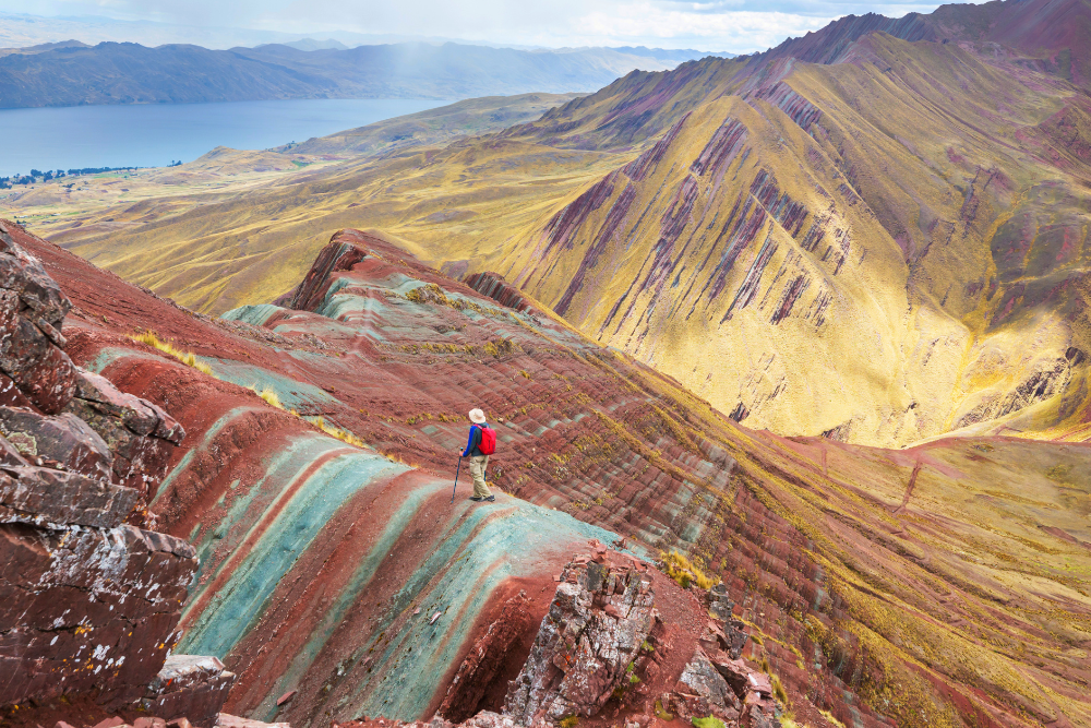 Hiker walking along a colorful mountain ridge with scenic views