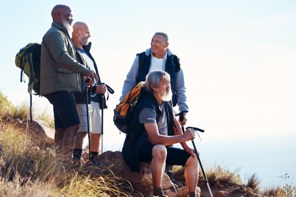 "Four senior men hiking and taking a break in nature."